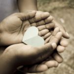 love; beautiful hands of children holding green heart shape